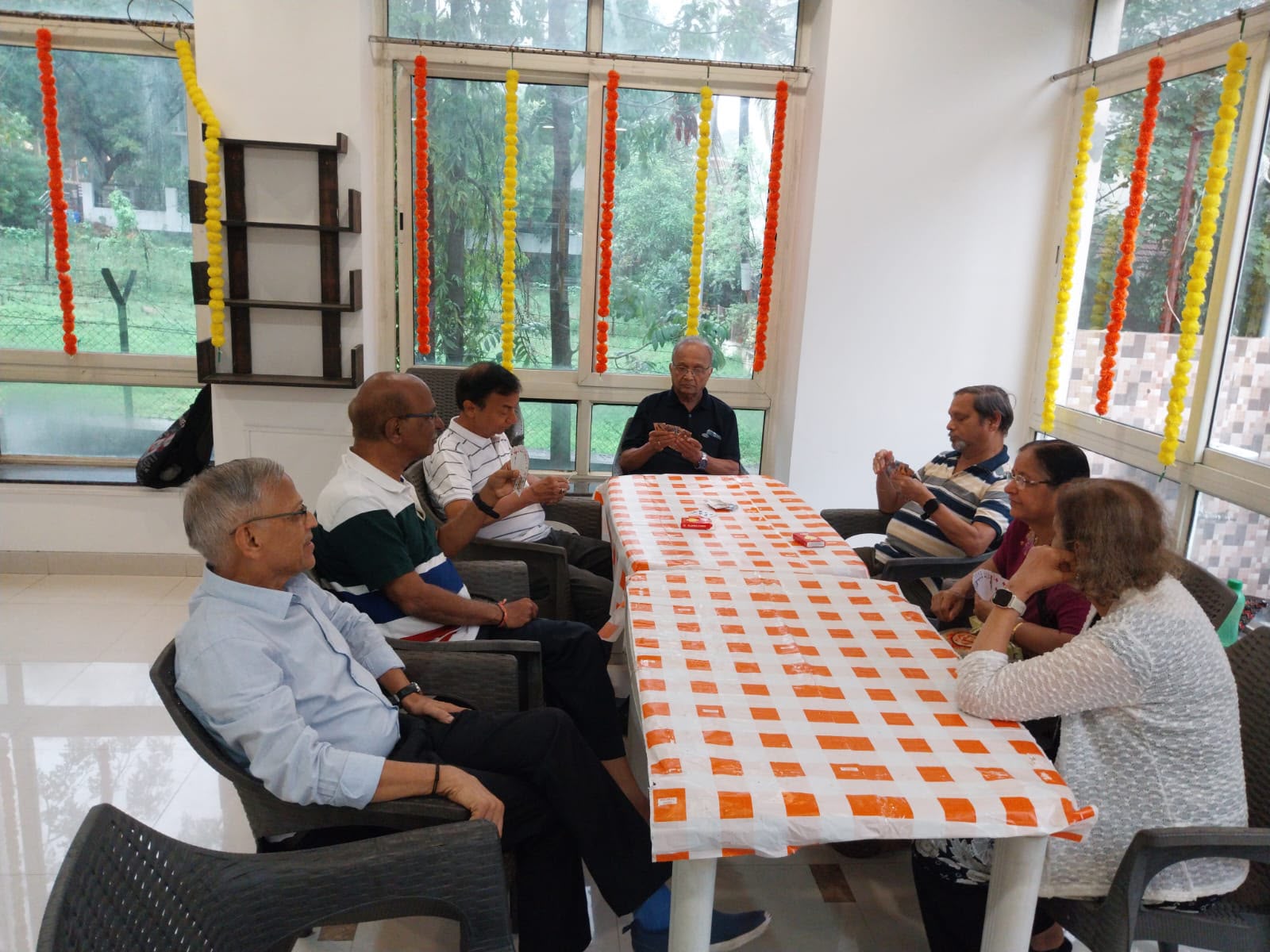 Senior men chatting poolside at Mahatma Society