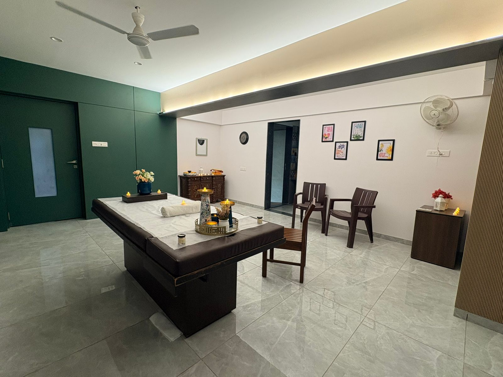 Spacious treatment room with massage table and warm lighting